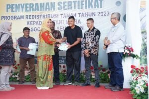 Penjabat Bupati Nagan Raya Menyerahkan Secara Simbolis Sertifikat Tanah kepada Petani Mitra PT Socfindo Seunagan