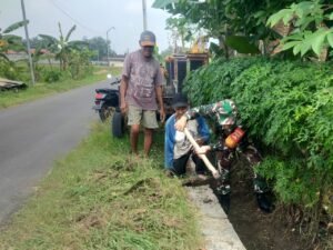 Babinsa Kerja Bakti Pembersihan Parit Dari Rumput Liar