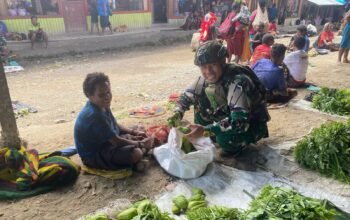 Personil Pos Sinak Satgas Yonif 700/WYC Belanja Hasil Tani Masyarakat di Pasar Sinak mama Papua tersenyum Bahagia