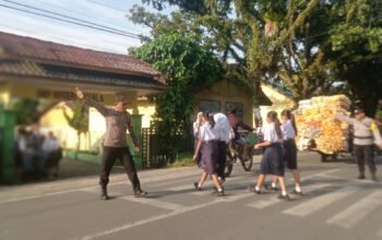 Polisi Hadir di Tengah Masyarakat, Bhabinkamtibmas Polsek Kuala Gatur Pagi di Depan SMPN 1 Kuala