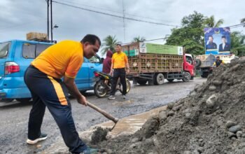 Bersama Warga, Personil Polsek Tanjung Pura Timbun Jalan Berlubang Demi Cegah Laka Lantas