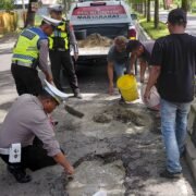 Demi Keselamatan Pengguna Jalan, Personil SAT Lantas Polres Langkat Tambal Jalan Berlubang